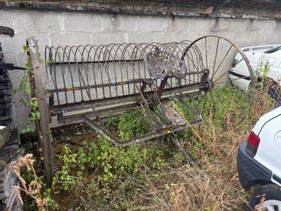 un banc posé dans l'herbe à côté d'une voiture