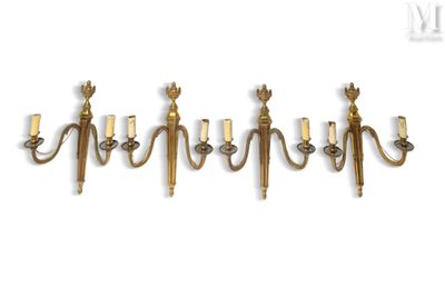 a set of five brass wall sconces on a white background