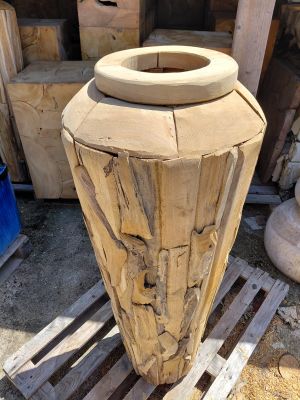 a large vase made out of wood sitting on a pallet