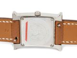 une image d'un gros plan d'une montre sur une surface blanche