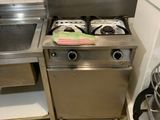 une petite cuisine équipée d'une cuisinière, d'un évier et d'un lave-vaisselle
