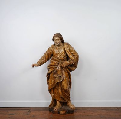 an old wooden statue of a man holding a cane