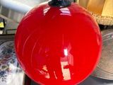 une boule rouge suspendue à une poignée noire posée sur une table