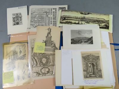 some of the drawings are on the table and some of them are in folders