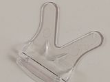 clear plastic hand holding a small plastic object on a white surface