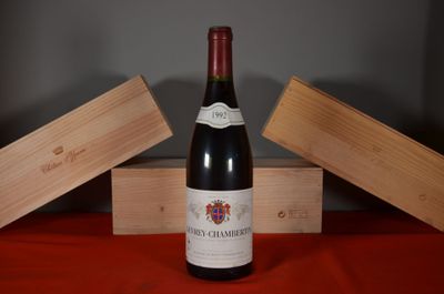 a bottle of wine sitting on a table next to two wooden boxes