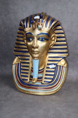 une image représentant un masque doré aux yeux bleus sur fond gris