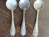 three spoons that are sitting on a table
