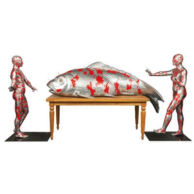 une sculpture représentant un poisson posée sur une table à côté d'une silhouette humaine