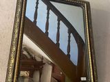 a mirror hanging on the wall next to a staircase