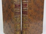 two old books sitting on top of each other on a white surface
