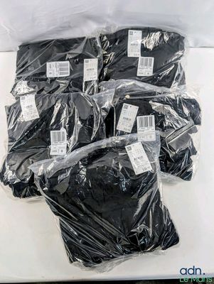 six bags of black underwear are wrapped in plastic on a white surface