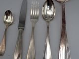 five silver spoons and two silver spoons on a table