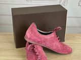 a pair of pink shoes sitting on top of a wooden table