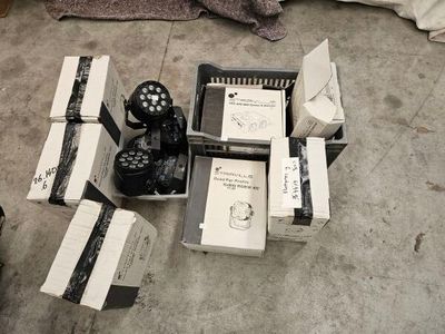 many boxes of electronic equipment on the floor next to a bed