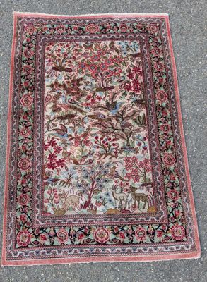 un tapis posé à même le sol, orné d'oiseaux et de fleurs
