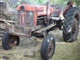 a red tractor that is parked in the grass