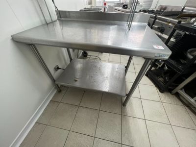 une table en acier inoxydable surmontée d'une étagère