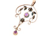 a close up of a pendant with a purple stone on it