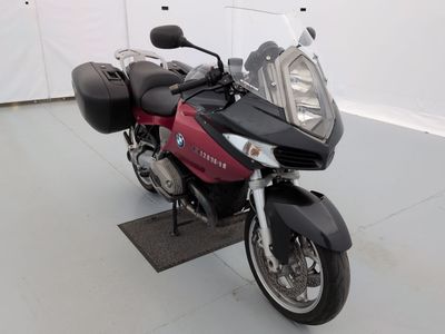 une moto rouge et noire garée dans une pièce blanche
