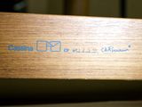 a close up of a wooden bench with a blue sticker on it