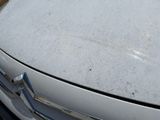 a white car that is parked on the side of the road