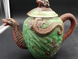 a green tea pot with a dragon on it