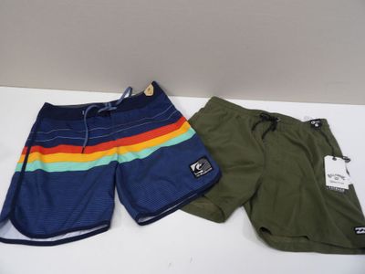 two men ' s swim trunks and shorts are on a white table