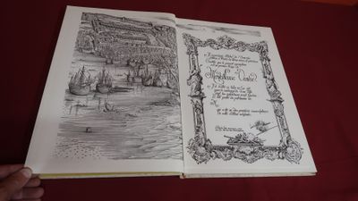 quelqu'un tient un livre ouvert sur lequel est dessiné un bateau