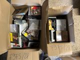 une boîte en carton remplie de DVD et de CD posée par terre