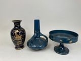 three vases and a bowl sitting on a table