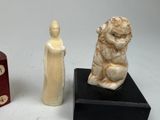 two figurines of a man and a dog on a table