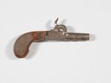 un vieux pistolet avec une poignée en bois sur une surface blanche