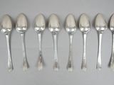 six silver spoons are lined up in a row on a table