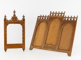 two pieces of wood with carvings and a mirror on a white surface
