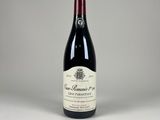 une bouteille de vin rouge posée sur une table blanche
