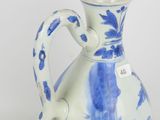 a blue and white vase with a handle on a white surface