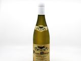 the bottle of wine is sitting on a white surface
