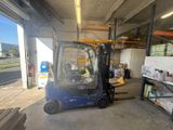 un chariot élévateur bleu garé dans un entrepôt