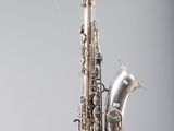une image représentant un saxophone argenté accroché au mur