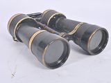 pair of black binoculars with gold trims on a white surface
