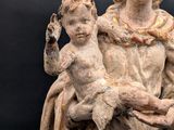 an old statue of a woman holding a child on a black background