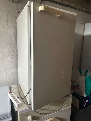 un réfrigérateur blanc et des toilettes blanches dans une pièce