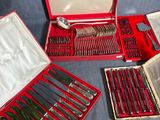 un coffret rouge contenant de l'argenterie, posé sur une nappe bleue