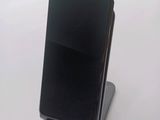 a black cell phone sitting on a stand on a table