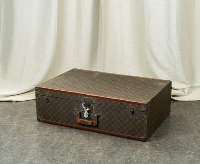 a suitcase sitting on the floor in front of a curtain