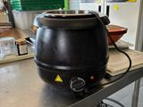 a large black pot on a table in a kitchen