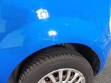 a close up of a blue car that is parked in a parking lot