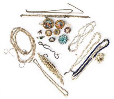 de nombreux colliers et bracelets de toutes sortes disposés sur une surface blanche