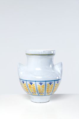 a white vase with a blue and yellow design on it